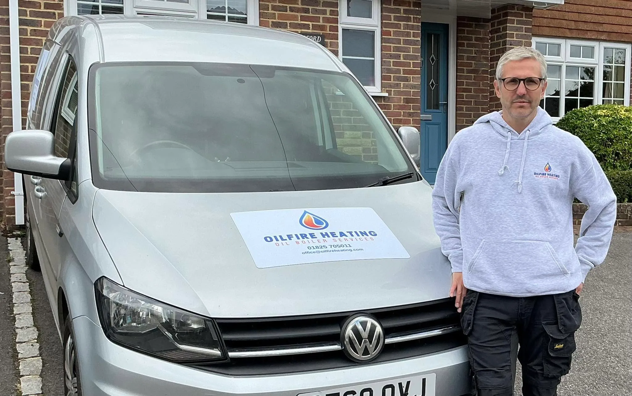 Steve Fretten standing beside the sign-written Oilfire Heating van on a customer's driveway